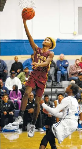  ?? STAFF PHOTO BY DOUG STRICKLAND ?? Tyner’s Xavier Fisher drives to the basket ahead of Arts &amp; Sciences’ Cahlib Edwards during Friday’s game at CSAS. Tyner won 69-52.