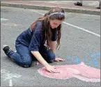  ??  ?? RIGHT: Joelle Woody,10, uses chalk to draw a heart on Broad Street.