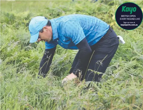  ??  ?? ROUGH START: Northern Ireland's Rory McIlroy looks for his ball in the long rough on the first hole during the first round of the British Open.
