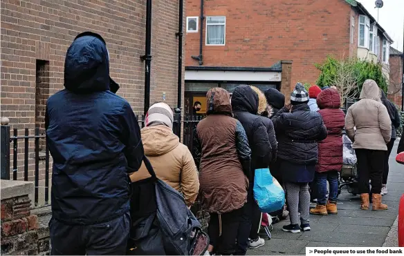  ?? ?? > People queue to use the food bank