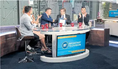  ??  ?? Co-host Kevin Frankish, centre, shakes hands with Mayor John Tory on his final day at Breakfast Television.