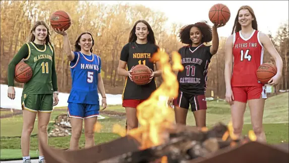  ?? Post-Gazette.com. Lucy Schaly/Post-Gazette ?? These five players were hotshots this season and they gather around a fire pit at “Shooters Golf” in Wexford. The Fab 5 players are, from left: Blackhawk’s Alena Fusetti, Armstrong’s Emma Paul, North Catholic’s Alayna Rocco (Player of the Year), Oakland Catholic’s London Creach and Peters Township’s Natalie Wetzel. View a Fab 5 video at