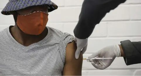  ?? Picture: AFP ?? JAB TIME. One of the first South African Oxford vaccine triallists watches a medical worker inject him at the Chris Hani Baragwanat­h Hospital in June last year.