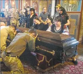  ?? Efrem Lukatsky Associated Press ?? UKRAINIAN soldiers mourn with the family and friends of a fellow fighter killed by Russian forces. The service took place at St. Michael’s Cathedral in Kyiv.