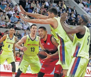  ??  ?? RODEADO. Nacho Martín intenta levantar el balón vigilado por Hanga, Heurtel, Oriola y Singleton.