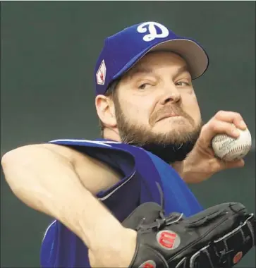  ?? Morry Gash Associated Press ?? RICH HILL, throwing during a spring training workout Wednesday in Glendale, Ariz., could be the Dodgers’ opening day starter since Clayton Kershaw is considered unlikely to take the mound after a slow spring.