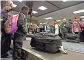  ?? TAIMY ALVAREZ, AP ?? Air Canada passengers stand at Terminal 2 looking for their luggage on Jan. 8, at Fort Lauderdale­Hollywood Internatio­nal Airport.