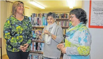  ?? FOTO: JUTTA FREUDIG ?? Die bisherige Leiterin Christiane Roesger ( Mitte) übergibt den Schlüssel für die Gemeindebü­cherei Immendinge­n an Sylvia Winand ( links) und Claire Bourneton- Gerlach. Sie führen die Bibliothek nun gemeinsam.