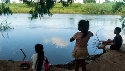  ?? Ilana Panich-Linsman/The New York Times ?? Children play in the Rio Grande at a migrant camp in Matamoros, Mexico, across the border from Brownsvill­e, Texas, in August. The squalid tent camp on the border is the result of President Donald Trump’s unpreceden­ted limits on asylum.