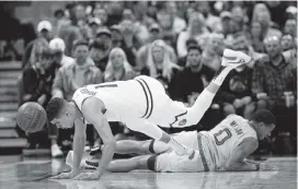  ?? DAVID ZALUBOWSKI AP ?? Nuggets forward Michael Porter Jr. loses control of the ball and his footing after colliding with Grizzlies guard De'Anthony Melton in the first half Saturday in Denver.