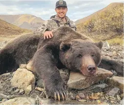  ??  ?? In this photo from his Twitter page, Tim Brent poses with the large grizzly bear he shot in Yukon.