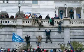  ?? (AP/Jose Luis Magana) ?? Supporters of then-President Donald Trump climb the west wall of the the U.S. Capitol on Jan. 6. Since the attack, Trump loyalists have worked to minimize the assault, while Democrats and others want justice for what they saw as a crime against democracy and the rule of law.