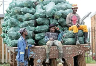  ?? /Siphiwe Sibeko/Reuters ?? Net increase: Farmworker­s rest while transporti­ng pumpkins. Research shows that the effects of the minimum wage were strongly positive.