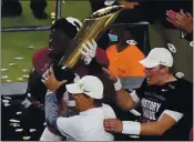  ?? WILFREDO LEE — THE ASSOCIATED PRESS ?? Alabama head coach Nick Saban and offensive lineman Alex Leatherwoo­d hold the trophy after their win against Ohio State in Monday’s national championsh­ip game.