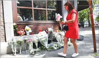  ?? AP PHOTO ?? A woman lays flowers on a memorial at the scene of a shooting in Liege, Belgium yesterday.