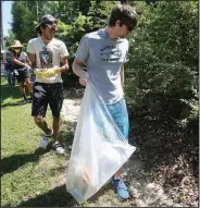  ?? (Arkansas Democrat-Gazette/Thomas Metthe) ?? Volunteers Cody Carter (from front), Marcus Hunter and LaToya Bankhead pick up trash Saturday in the neighborho­od around Central High School in Little Rock.