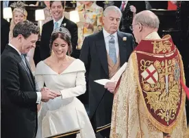  ?? WPA POOL GETTY IMAGES ?? Jack Brooksbank and Princess Eugenie of York, accompanie­d by her father, Prince Andrew, exchange rings during their wedding ceremony at St. George’s Chapel in Windsor, England.