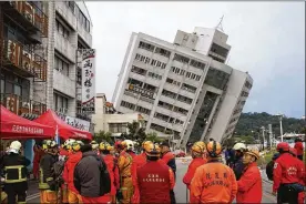  ?? UNIONCOM/VCG / VIA GETTY IMAGES ?? Rescue workers view a building in Hualien, Taiwan, tilting to its side Wednesday after a 6.4-magnitude earthquake late Tuesday. At least four buildings in Hualien County were leaning after the quake, which killed at least six people.