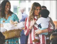  ?? The Associated Press ?? SOLO TRIP: First lady Melania Trump holds a baby as she visits Greater Accra Regional Hospital in Accra, Ghana on Tuesday. The first lady is visiting Africa on her first big solo internatio­nal trip, aiming to make child well-being the focus of a five-day, four-country tour.
