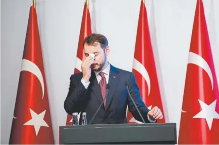  ?? Mucahid Yapici, The Associated Press ?? Berat Albayrak, Turkey’s treasury and finance minister, wipes his forehead Friday during a conference in Istanbul that was called to ease investor concerns about the economic health of Turkey.