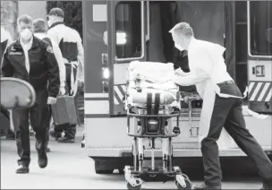  ?? REUTERS/David Ryder ?? A medic prepares a stretcher to transfer a patient into an ambulance at the Life Care Center of Kirkland, the long-term care facility linked to several confirmed coronaviru­s cases in the state, in Kirkland, Washington, U.S. March 5, 2020.