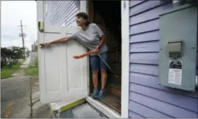  ?? AP PHOTO/GERALD HERBERT ?? Luz Ramirez closes the door af one of her sone’s short-term rental properties after cleaning it, in Mid City New Orleans. New Orleans officials are looking at the benefits and headaches of the vacation rental industry that has proliferat­ed with the growth of online sites such as Airbnb.