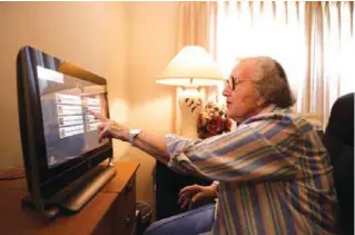  ?? — MCT ?? CALIFORNIA: Pat Holland, 88, demonstrat­es VideoCare in her room at Vintage Senior Living in San Jose, California. VideoCare enables seniors to stay in touch with family members.