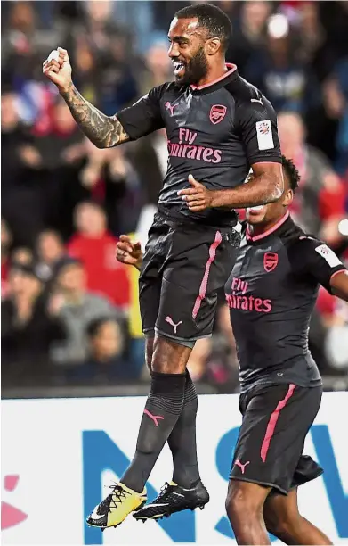  ?? — AFP ?? Great start: Alexandre Lacazette jumping for joy after scoring for Arsenal against Sydney FC in a friendly in Sydney yesterday. Arsenal won 2- 0.