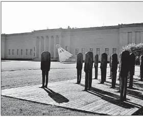  ?? Claes Oldenburg’s famous Shuttlecoc­k sculpture can be viewed through Magdalena Abakanowic­z’s Standing Figures on the grounds of the Nelson-Atkins Museum of Art. ??