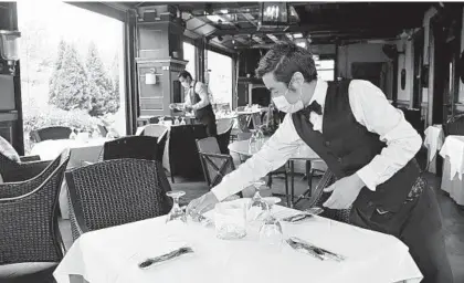  ?? LLOYD FOX/BALTIMORE SUN ?? Kiran Oli and Lopsang Lama set an outdoor dining area Thursday at Ananda, a restaurant in Fulton, in preparatio­n for Friday’s reopening.