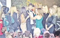  ?? — AFP photos ?? The winner (centre) is congratula­ted by French designer and fashion editor Carine Roitfeld after he won the auction on Thursday during the amfAR charity event. (Top) Heidi Klum and US-Puerto Rican actor Benicio Del Toro (right) conduct an auction on...