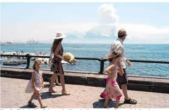  ??  ?? Diese Familie beobachtet die brennenden Hänge des Vesuvs von einer Promenade in Neapel