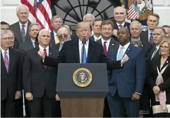  ?? PHOTO: CAROLYN KASTER/AP ?? MAJOR VICTORY: Surrounded by members of Congress, US President Donald Trump celebrates the passage of his tax overhaul legislatio­n.