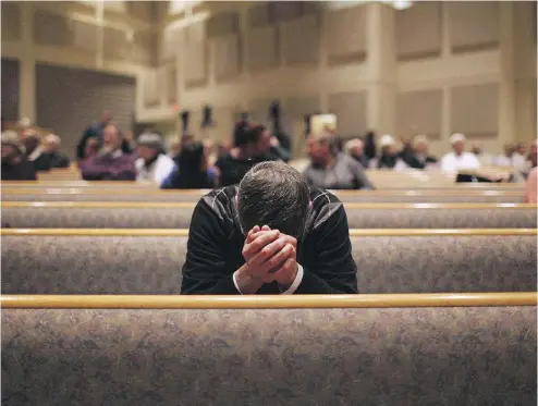  ?? ANDRAYA CROF / THE ASSOCIATED PRESS ?? A member of the community prays Sunday in Kalamazoo, Mich., where a gunman killed six people on the weekend.