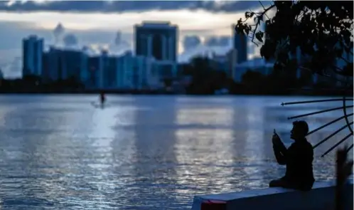  ?? CARLOS GIUSTI/AP/FILE ?? A man took pictures with his cellphone on the banks of the Condado lagoon in San Juan in September 2021.