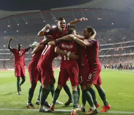  ?? ARMANDO FRANCA/THE ASSOCIATED PRESS ?? Portugal’s Andre Silva celebrates with his teammates after scoring a goal in his nation’s 2-0 win against Switzerlan­d on Tuesday.