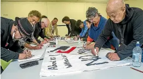  ?? WARWICK SMITH/STUFF ?? Protesters create banners to protest the Manawatu¯ District Council’s decision not to have Ma¯ori wards.