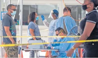  ??  ?? PRUEBA. Personal sanitario toma una muestra para detectar covid-19 a una mujer en el estado de Florida.