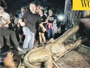  ?? JULIA WALL / THE NEWS & OBSERVER VIA AP ?? Protesters celebrate after the Confederat­e statue known as “Silent Sam” was toppled on the campus of the University of North Carolina in Chapel Hill, N.C., during a demonstrat­ion on Monday.