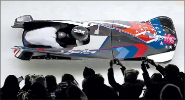 ?? AP/MICHAEL SOHN ?? Fans watch as Americans Elana Meyers Taylor (front) and Lauren Gibbs streak past during their final run in women’s two-man bobsled Wednesday at the Alpensia Sliding Centre in Pyeongchan­g, South Korea. Taylor and Gibbs won the silver medal in the event.