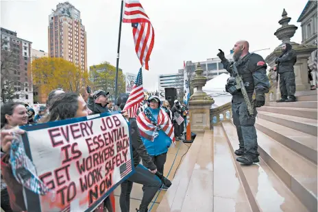  ?? MATTHEW DAE SMITH/LANSING STATE JOURNAL ?? Protesters rally to denounce Gov. Gretchen Whitmer’s stay-at-home order and business restrictio­ns due to COVID-19 on April 30 at the state Capitol in Lansing, Michigan.