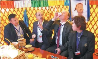  ?? ZOU HONG / CHINA DAILY ?? Delegates from around the world attending a meeting of the Conference of the Parties to the UN Convention to Combat Desertific­ation, in Ordos, Inner Mongolia autonomous region, get a taste of local food, drink and culture on Monday.