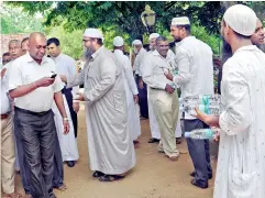  ??  ?? A group of Muslims are seen distributi­ng bottles of water to the people who have come to pay their last respects to the Ven. Maduluwawe Sobitha Thera at the Kotte Sri Naga Viharaya.