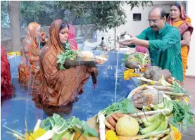  ?? — G.N. JHA ?? People perform rituals on the occasion of Chhath Puja in Gurgaon on Sunday.