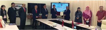  ??  ?? Dr Ngui (fifth right) exchanges the MoU document with Mohamad Kadim (fourth right)