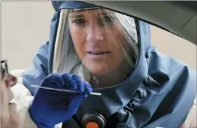  ?? RICK BOWMER — THE ASSOCIATED PRESS ?? Salt Lake County Health Department public health nurse Lee Cherie Booth performs a coronaviru­s test Friday outside the Salt Lake County Health Department in Salt Lake City.