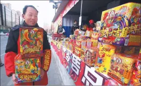  ?? CHEN XIAOGEN / FOR CHINA DAILY ?? A worker carries fireworks to put on display at a temporary sales outlet in Beijing’s Chaoyang district on Monday.