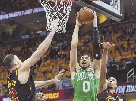  ?? STAFF PHOTO BY CHRISTOPHE­R EVANS ?? DOUBLE TROUBLE: Jayson Tatum tries to go to the hoop against the defense of the Cavaliers’ Larry Nance Jr. (left) and George Hill (right) during the Celtics’ Game 4 loss Monday night in Cleveland.