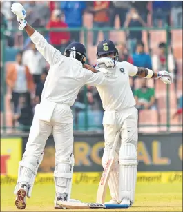  ??  ?? Indian cricketer Murali Vijay celebrates with skipper Virat Kohli after completing his century against Sri Lanka during the first day of the third cricket test match at Feroz Shah Kotla, in New Delhi on Saturday.