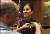  ?? WILLIAMS PIONEER REVIEW VIA AP ?? Merced Corona pinning his daughter Natalie Corona’s badge on her uniform during a swearing- in ceremony in Davis, Aug. 2, 2018 .